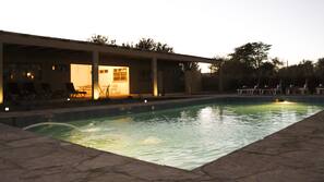 Una piscina al aire libre, tumbonas