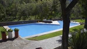 Una piscina al aire libre, tumbonas