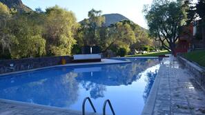 Una piscina al aire libre, tumbonas