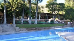 Una piscina al aire libre, tumbonas