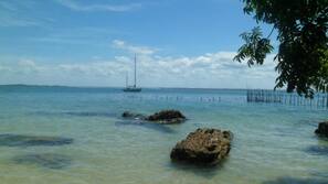 Na praia, espreguiçadeiras, guarda-sóis, toalhas de praia
