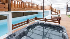 Una piscina cubierta, una piscina al aire libre, tumbonas