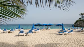 On the beach, white sand, sun loungers, beach towels