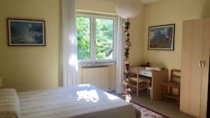 Escritorio, cortinas opacas, tabla de planchar con plancha