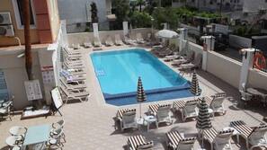 Piscine extérieure, parasols de plage, chaises longues