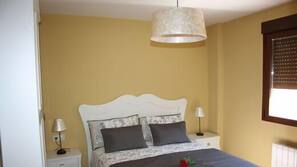 1 dormitorio y tabla de planchar con plancha