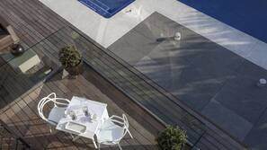 Una piscina al aire libre, sombrillas, tumbonas