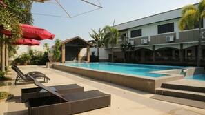 Una piscina al aire libre, sombrillas, tumbonas
