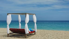 Aan het strand, wit zand, ligstoelen aan het strand, parasols