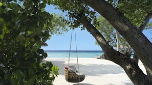 Am Strand, weißer Sandstrand, Liegestühle, Sonnenschirme