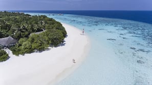 Am Strand, weißer Sandstrand, Liegestühle, Sonnenschirme