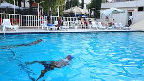 Piscine extérieure, parasols de plage, chaises longues