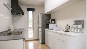 Frigorífico grande, microondas, placa de cocina y utensilios de cocina