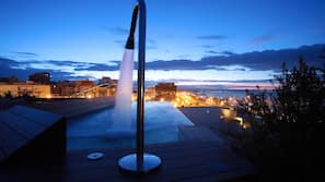 Una piscina cubierta, una piscina al aire libre, tumbonas