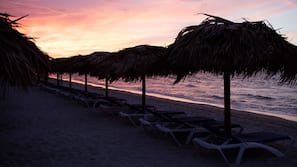 Sulla spiaggia, sabbia bianca, lettini da mare, teli da spiaggia