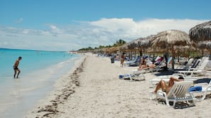 Sulla spiaggia, sabbia bianca, lettini da mare, teli da spiaggia