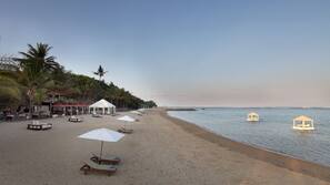 Am Strand, weißer Sandstrand, Liegestühle, Sonnenschirme