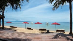 Am Strand, weißer Sandstrand, Liegestühle, Sonnenschirme