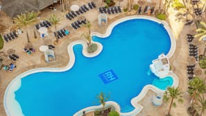 Una piscina cubierta, una piscina al aire libre, sombrillas, tumbonas