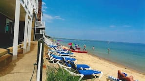 Praia particular, espreguiçadeiras, guarda-sóis, toalhas de praia