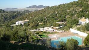 Una piscina al aire libre de temporada, sombrillas, tumbonas