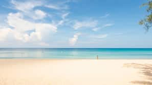 On the beach, white sand, sun-loungers, beach umbrellas