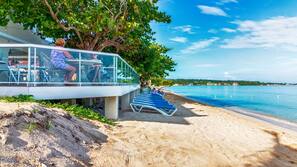 On the beach, white sand, sun-loungers, beach towels