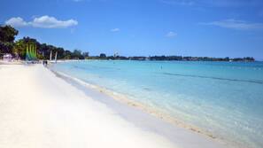 Playa privada, arena blanca, toallas de playa y submarinismo