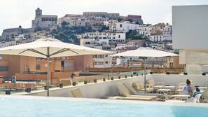 Una piscina al aire libre de temporada, sombrillas, tumbonas