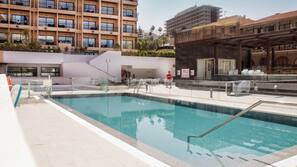 Una piscina al aire libre, tumbonas