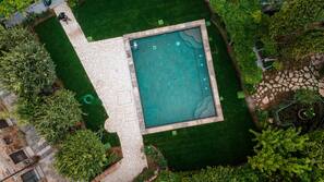 Una piscina al aire libre de temporada, sombrillas, tumbonas