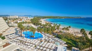 Piscine couverte, piscine extérieure, parasols de plage, chaises longues