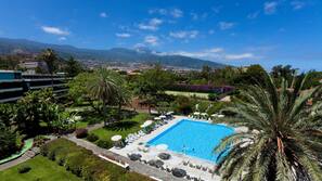 Una piscina al aire libre, sombrillas, tumbonas
