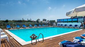 Una piscina al aire libre, tumbonas