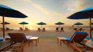 On the beach, white sand, beach umbrellas, beach towels