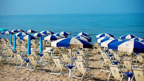 Sulla spiaggia, lettini da mare, ombrelloni, teli da spiaggia