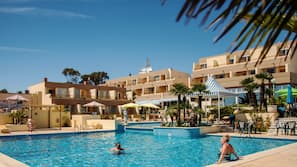 Una piscina cubierta, una piscina al aire libre, sombrillas, tumbonas