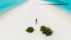 Plage privée, sable blanc, chaises longues, serviettes de plage