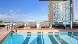 En säsongsöppen utomhuspool och solstolar