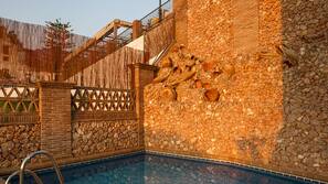 Una piscina al aire libre de temporada, sombrillas, tumbonas