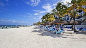 On the beach, white sand, sun loungers, beach umbrellas