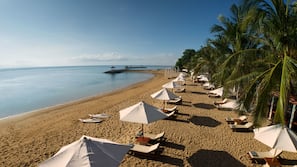 On the beach, white sand, sun-loungers, beach umbrellas