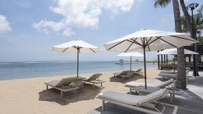 On the beach, white sand, sun-loungers, beach umbrellas