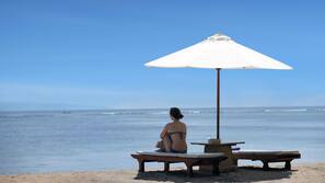 On the beach, white sand, sun-loungers, beach umbrellas