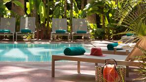Una piscina al aire libre, sombrillas, tumbonas