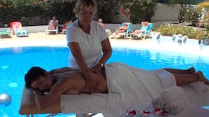 Una piscina al aire libre, sombrillas, tumbonas