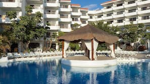 Una piscina al aire libre, sombrillas, tumbonas