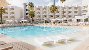 Una piscina cubierta, una piscina al aire libre, sombrillas, tumbonas