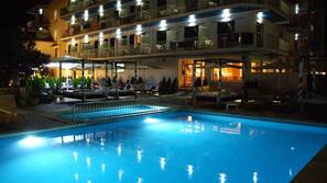 Una piscina al aire libre de temporada, sombrillas, tumbonas