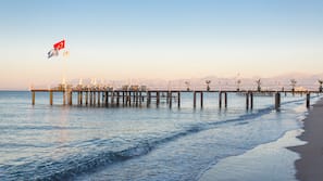 Een privéstrand, ligstoelen aan het strand, parasols, strandlakens